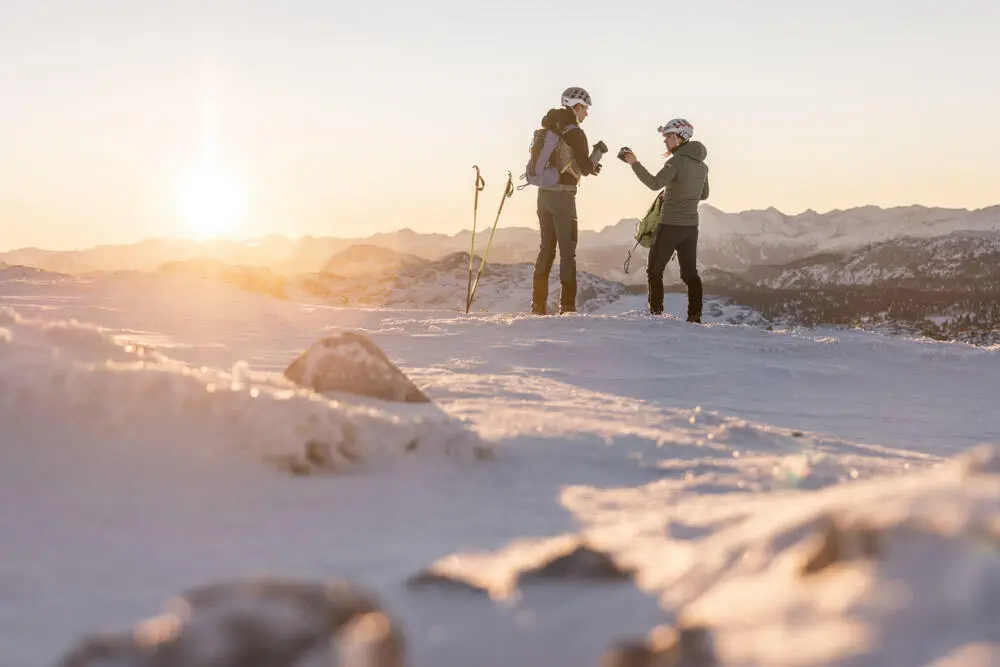 OOE-Tourismus-Dachstein-Salzkammergut-Michael-Groessinger Eine Frau und ein Mann stehen bei Sonnenaufgang auf der Hochfläche des Dachsteingebietes.