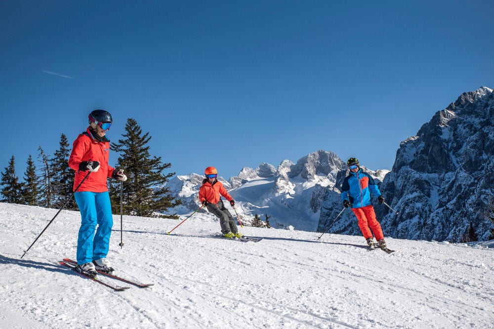 Familie-Skishooting-Dachstein-West-Gosau-Foto-RudiKainPhotografie Eine Familie die eine Skipiste mit ihren Skier herunterfahren